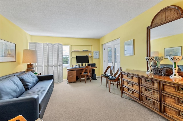 carpeted office space with french doors and a textured ceiling