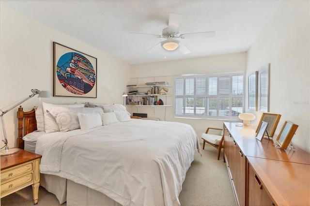 bedroom featuring ceiling fan, light carpet, and a textured ceiling