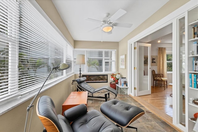 sunroom / solarium featuring french doors and ceiling fan