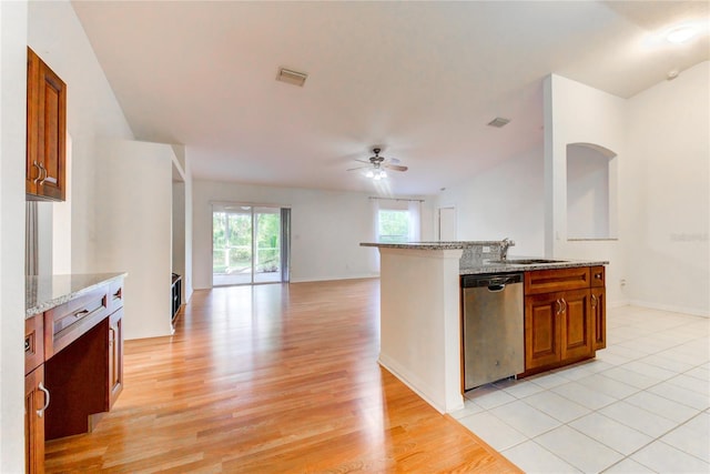 kitchen featuring light stone counters, ceiling fan, sink, dishwasher, and light hardwood / wood-style floors