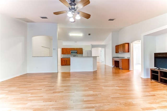 unfurnished living room featuring ceiling fan and light hardwood / wood-style flooring