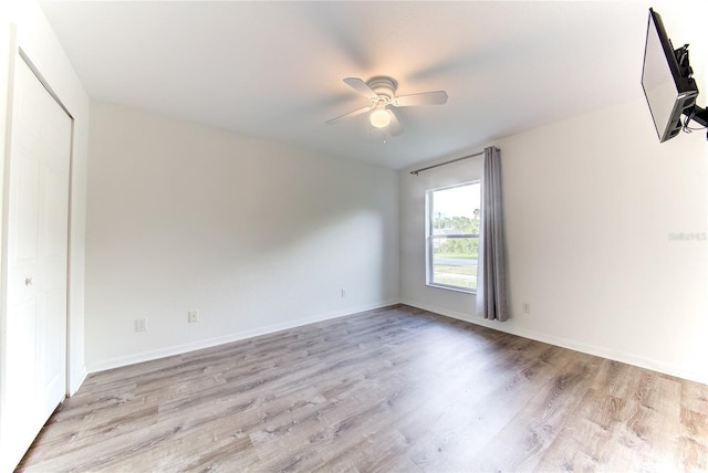 spare room with ceiling fan and light wood-type flooring