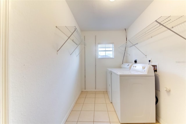 laundry area with washer and dryer and light tile patterned flooring