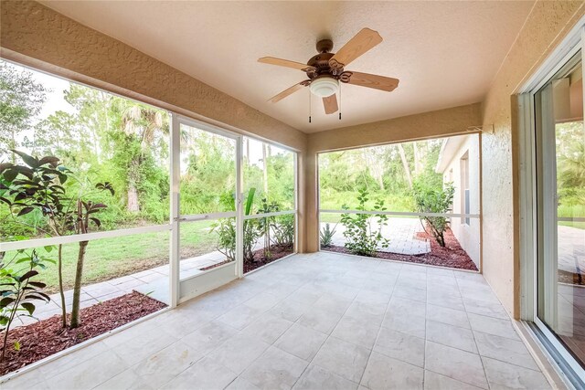 unfurnished sunroom featuring ceiling fan