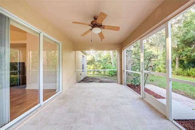 unfurnished sunroom featuring ceiling fan