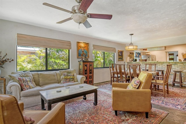 living room featuring a textured ceiling and ceiling fan