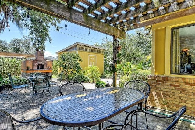 view of patio featuring an outdoor brick fireplace, a shed, and a pergola