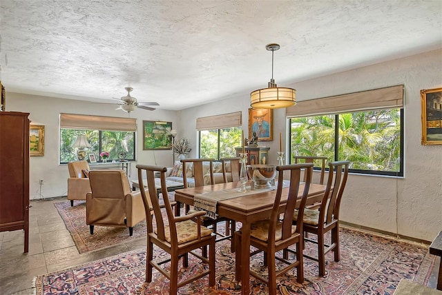 dining space featuring ceiling fan and a textured ceiling