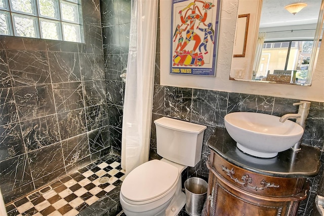 bathroom with tile walls, a wealth of natural light, and walk in shower