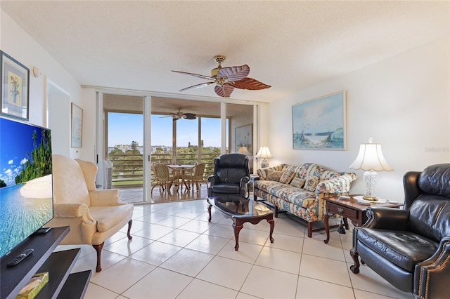 living room with a textured ceiling, ceiling fan, light tile patterned floors, and floor to ceiling windows