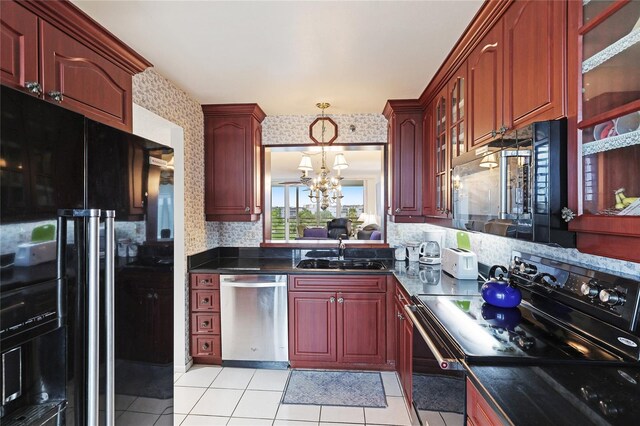 kitchen featuring black appliances, sink, hanging light fixtures, backsplash, and light tile patterned floors