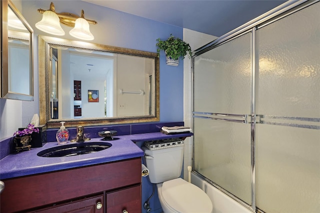 full bathroom with bath / shower combo with glass door, toilet, and vanity