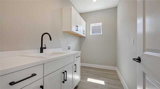 laundry room featuring sink, cabinets, and hookup for a washing machine