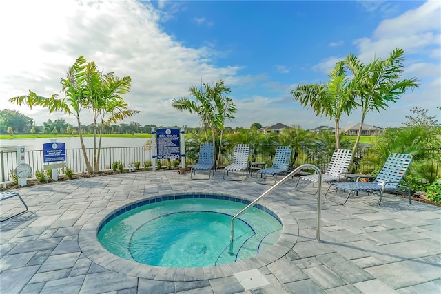 view of swimming pool featuring a water view, a patio, and a community hot tub