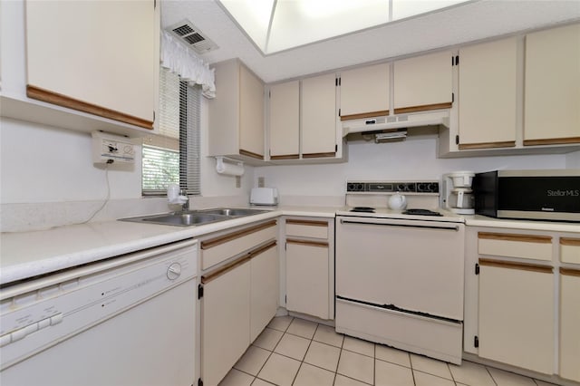 kitchen with white appliances, sink, and light tile floors