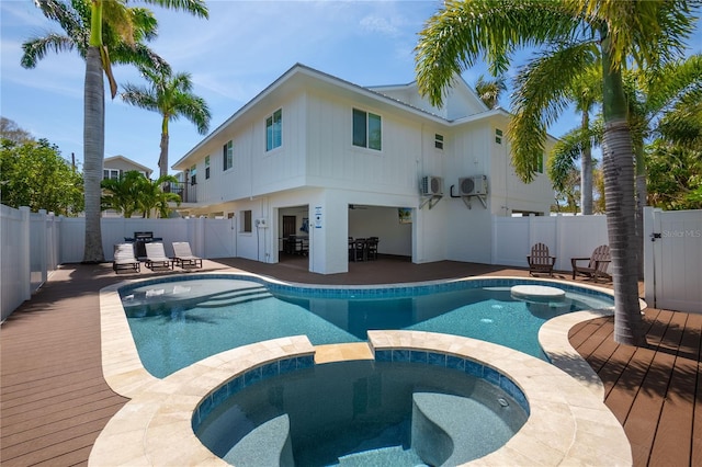 view of pool featuring an in ground hot tub, an AC wall unit, and a patio area