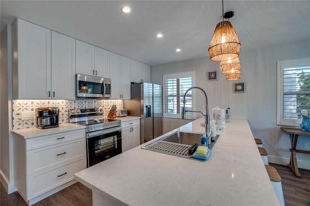 kitchen featuring appliances with stainless steel finishes, backsplash, and white cabinetry