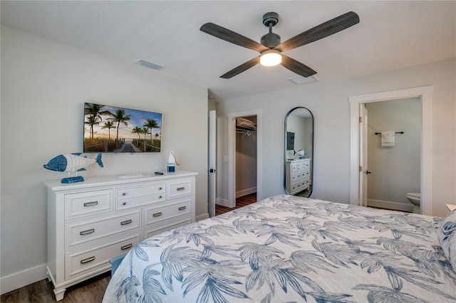 bedroom featuring a walk in closet, ensuite bath, ceiling fan, dark hardwood / wood-style floors, and a closet