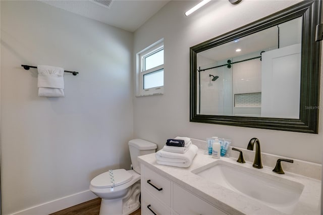 bathroom with vanity, hardwood / wood-style flooring, toilet, and a shower with door