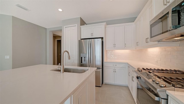 kitchen with white cabinetry, sink, tasteful backsplash, and stainless steel appliances