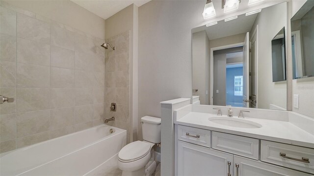 full bathroom featuring toilet, tiled shower / bath combo, and large vanity