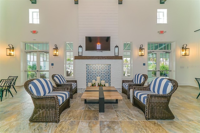 tiled living room featuring a towering ceiling and a healthy amount of sunlight