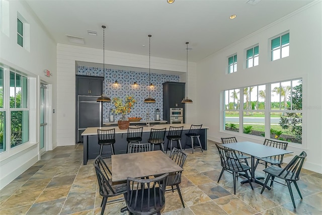 dining space with ornamental molding and a high ceiling