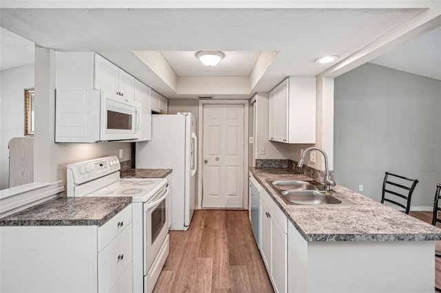 kitchen featuring white cabinetry, sink, light hardwood / wood-style flooring, a textured ceiling, and white appliances