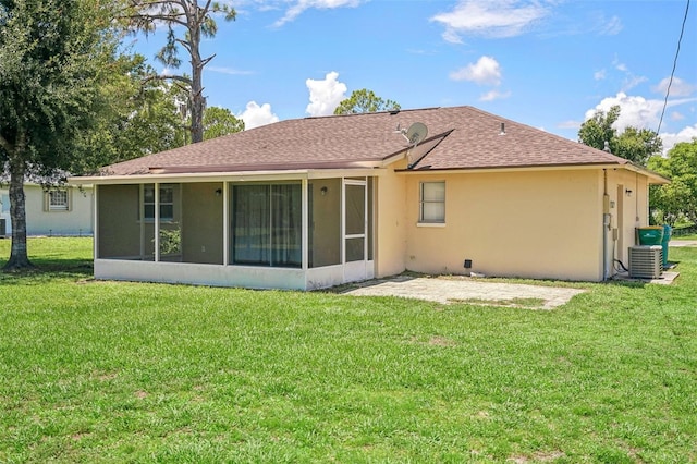 back of property featuring a lawn, central air condition unit, and a sunroom