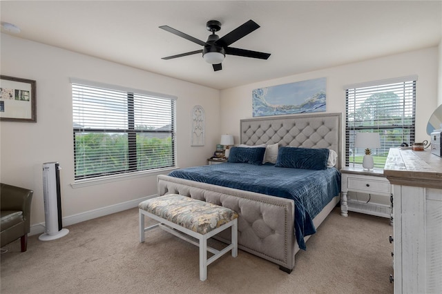 carpeted bedroom featuring multiple windows and ceiling fan