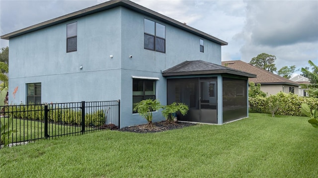 rear view of house featuring a lawn and a sunroom