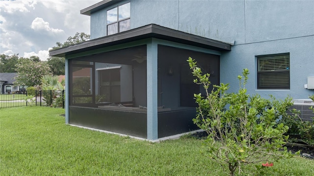 view of property exterior with a sunroom and a lawn