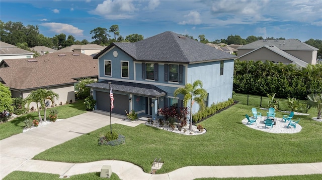 view of front of property featuring an outdoor fire pit, a front yard, and a garage