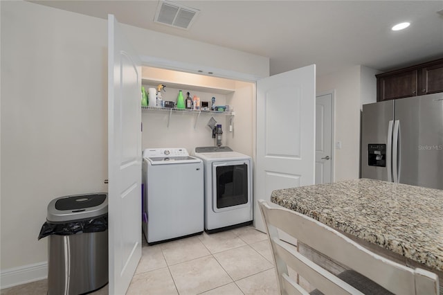 clothes washing area featuring washing machine and clothes dryer and light tile patterned floors