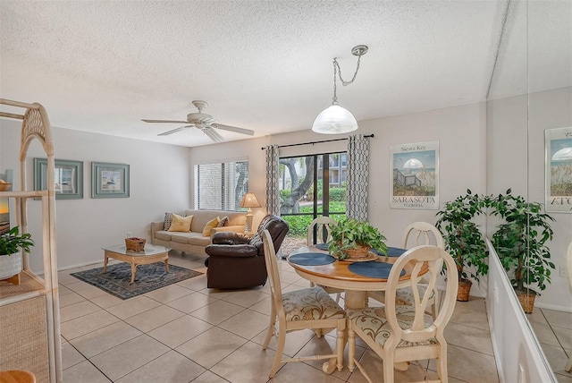 tiled dining space with ceiling fan and a textured ceiling