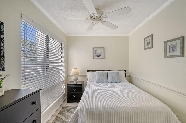 bedroom featuring crown molding, a textured ceiling, light tile patterned floors, and ceiling fan