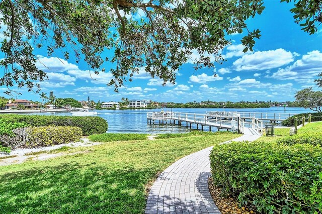 view of dock with a water view and a lawn