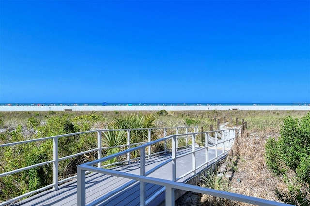 exterior space with a balcony, a water view, and a beach view