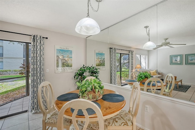 dining area with a textured ceiling, light tile patterned flooring, and ceiling fan