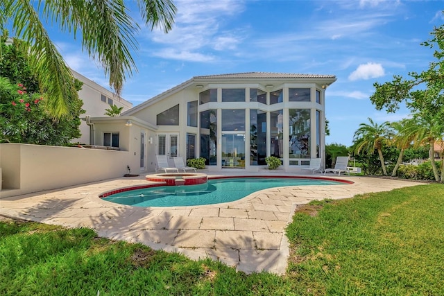 view of swimming pool featuring a patio area, an in ground hot tub, and a sunroom