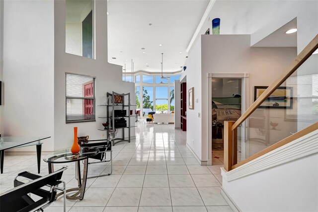 interior space featuring a chandelier, a towering ceiling, and light tile patterned floors