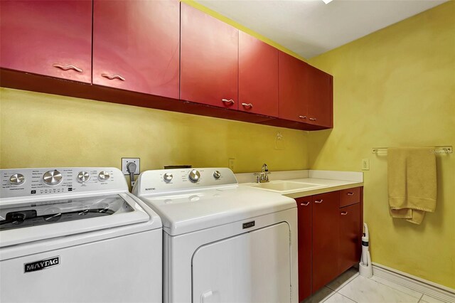 laundry area featuring cabinets, sink, light tile patterned flooring, and washer and dryer