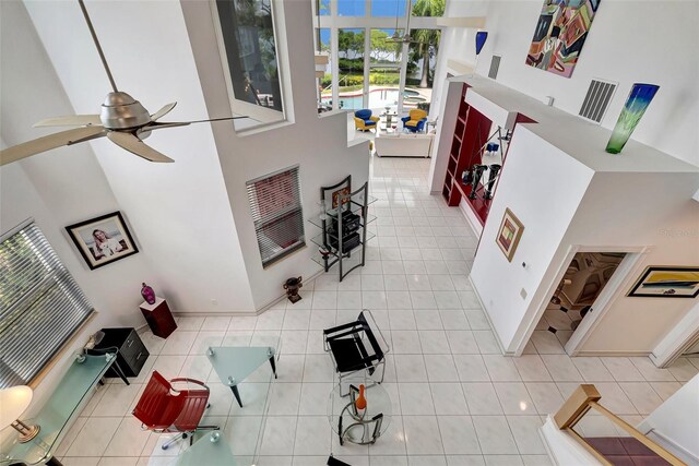 tiled living room with a high ceiling and ceiling fan