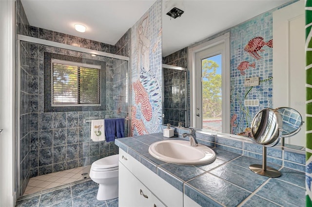 bathroom featuring tile patterned flooring, toilet, vanity, and plenty of natural light