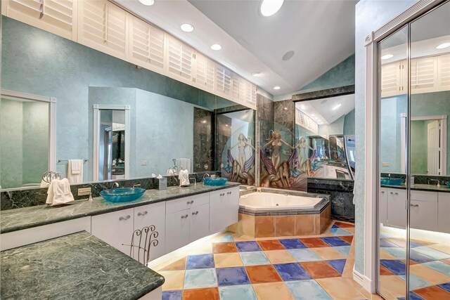 bathroom with a relaxing tiled tub, vanity, tile patterned flooring, and high vaulted ceiling