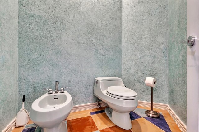 bathroom featuring a bidet, toilet, and tile patterned flooring