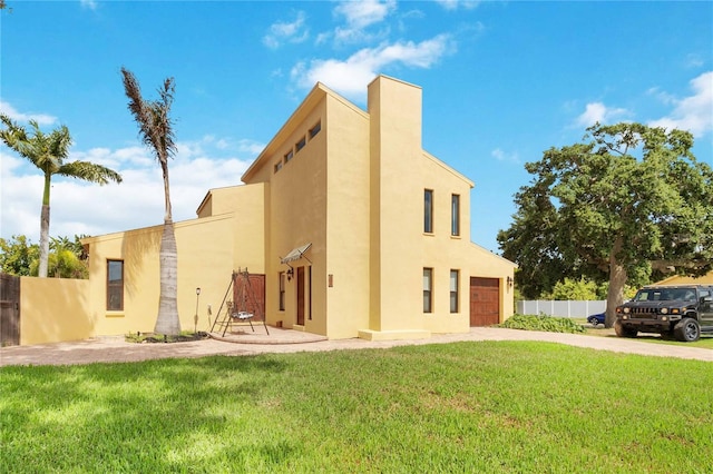 rear view of house with a garage and a yard