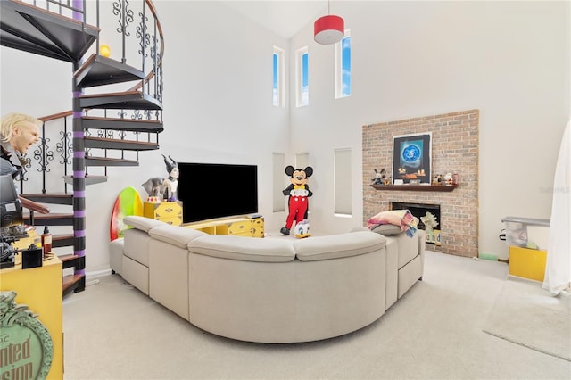 living room featuring a towering ceiling, light colored carpet, and a fireplace