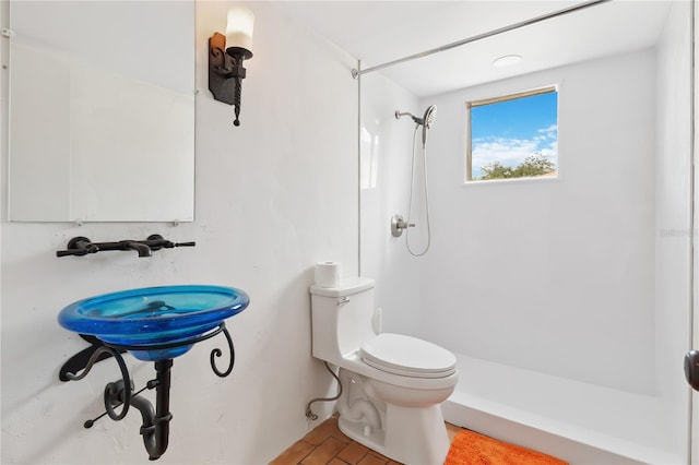 bathroom with toilet, tile patterned floors, and walk in shower