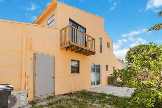 rear view of house with a balcony and ac unit